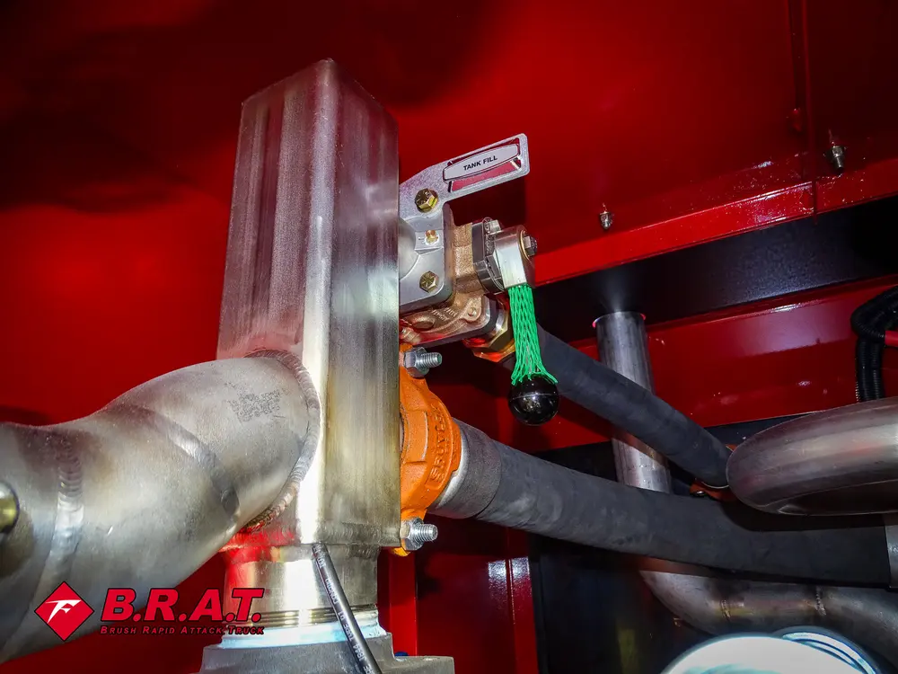 Exterior view of small fire truck showing cab, body compartments, and wheel/tire area.