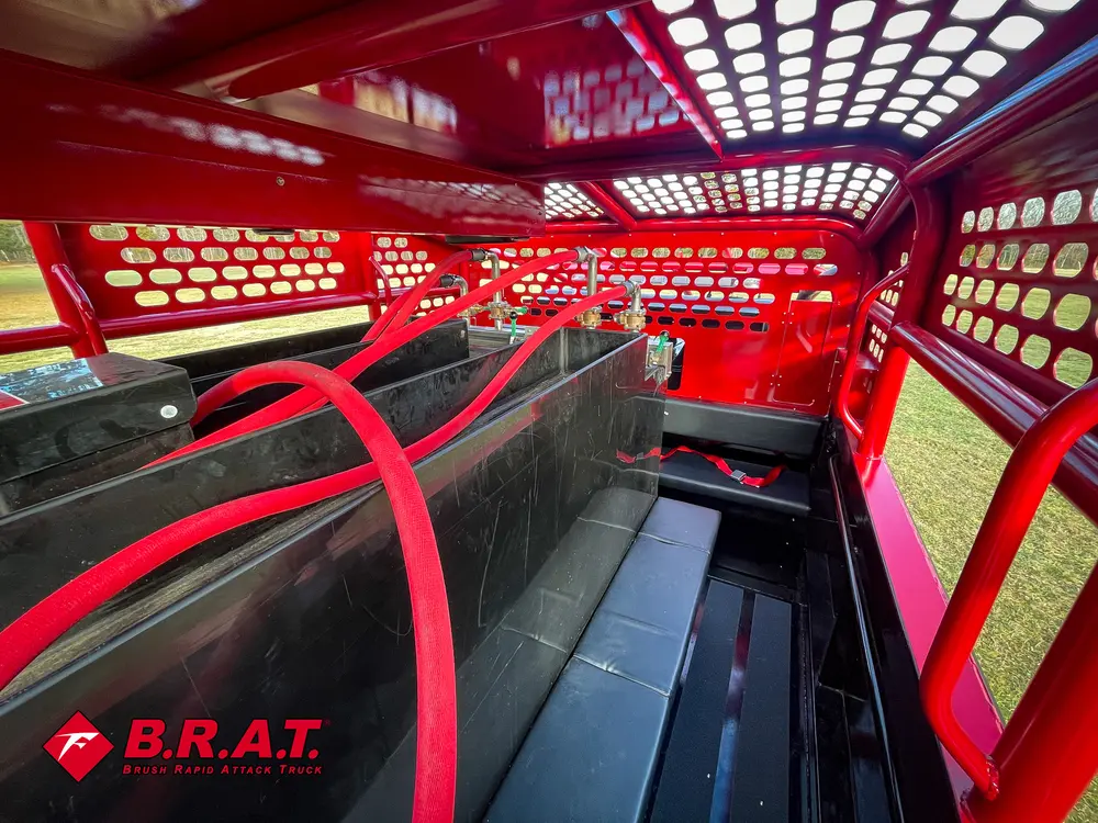 Exterior view of small fire truck showing cab, body compartments, and wheel/tire area.