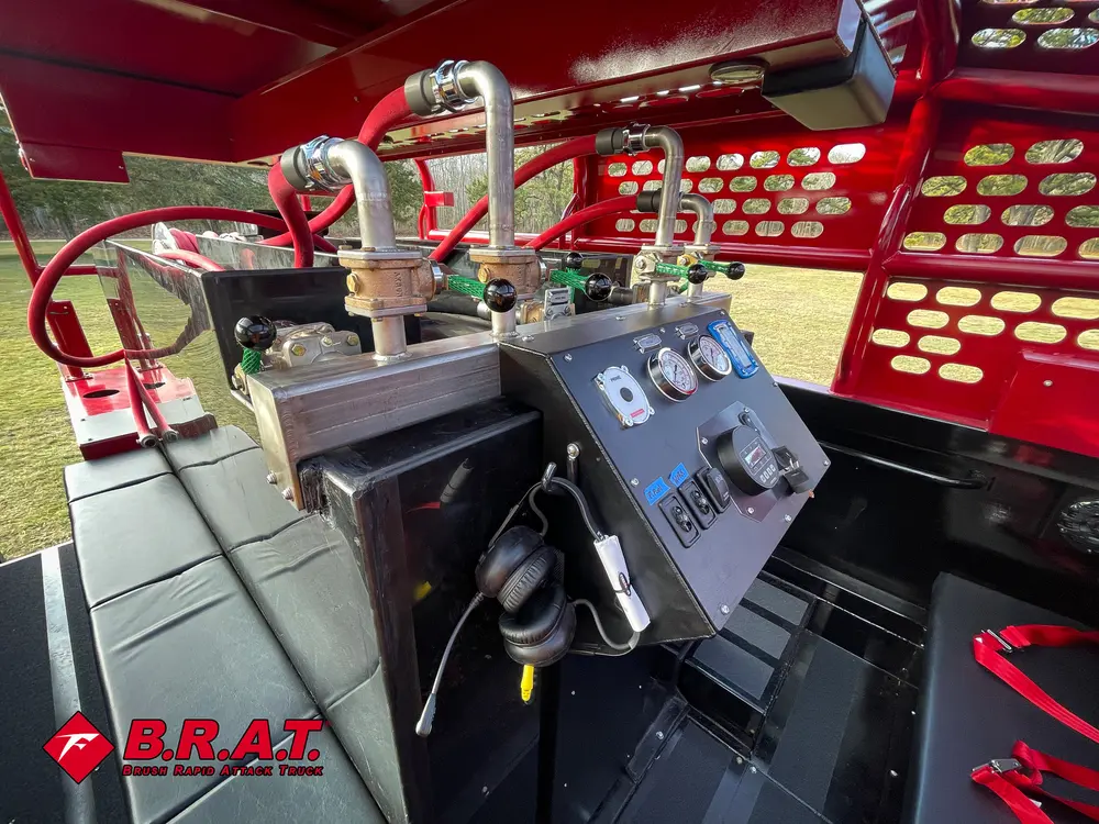 Exterior view of small fire truck showing cab, body compartments, and wheel/tire area.