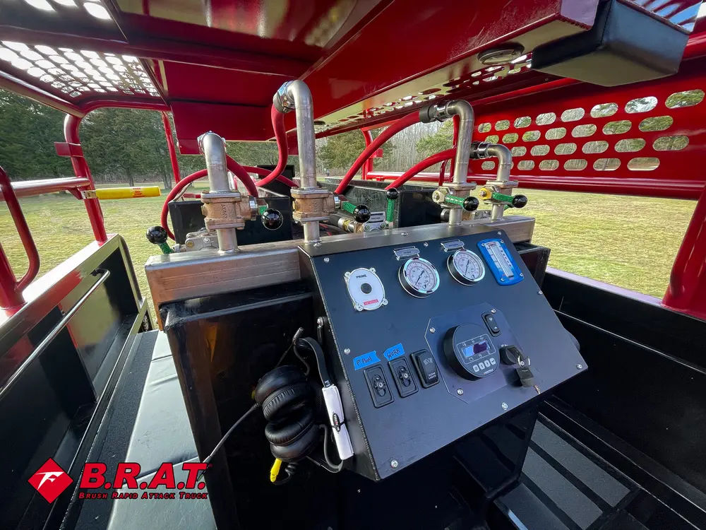 Exterior view of small fire truck showing cab, body compartments, and wheel/tire area.