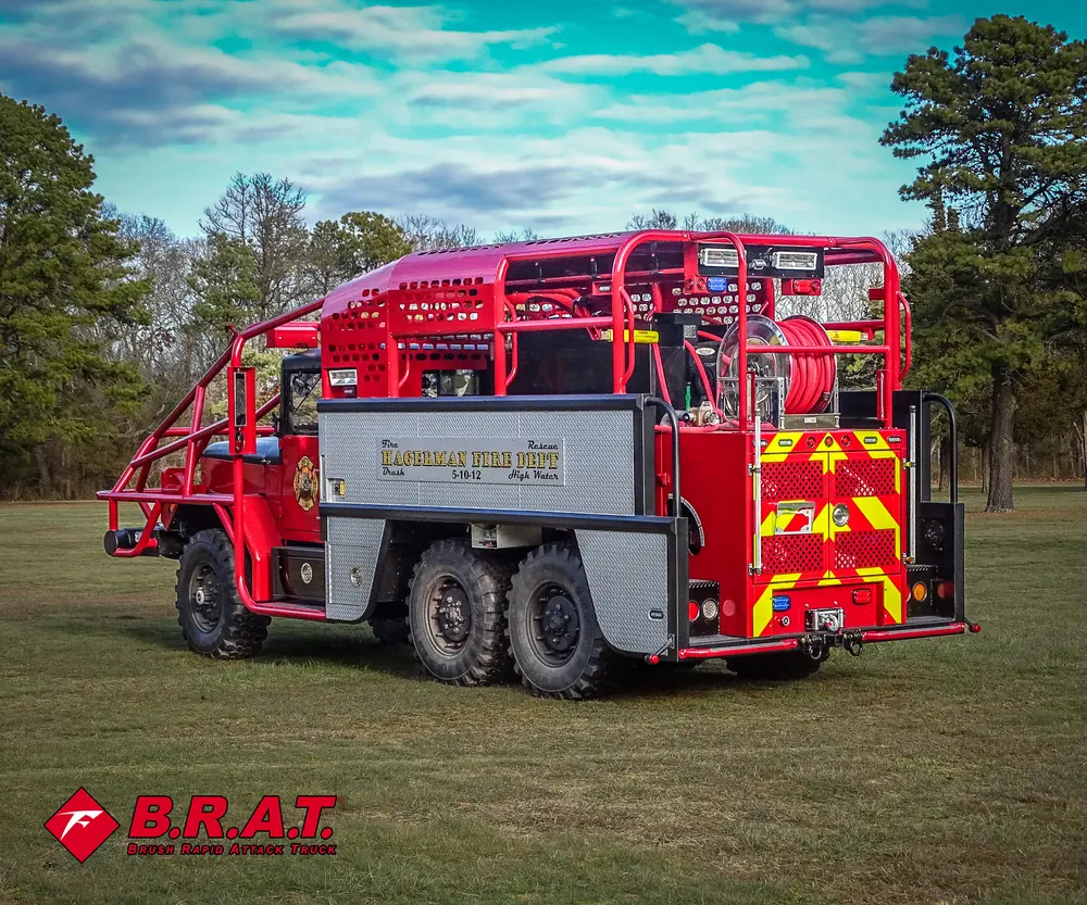 Exterior view of small fire truck showing cab, body compartments, and wheel/tire area.