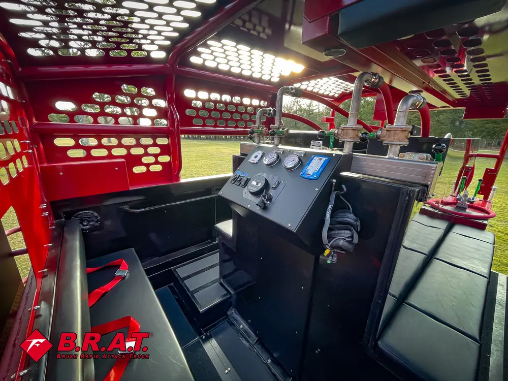 Exterior view of small fire truck showing cab, body compartments, and wheel/tire area.