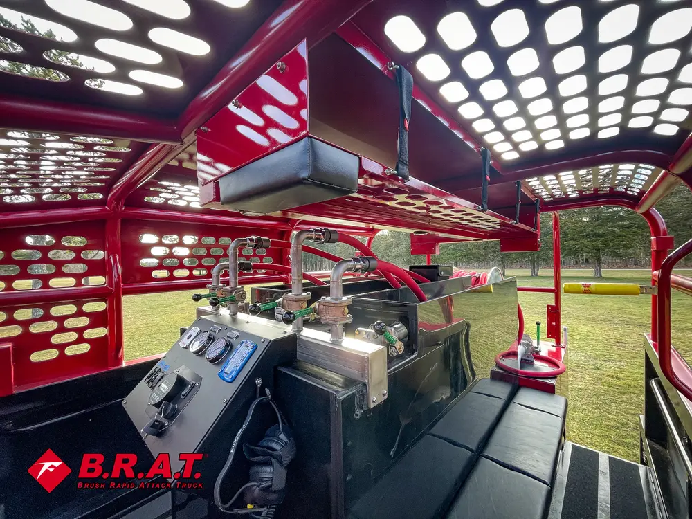 Exterior view of small fire truck showing cab, body compartments, and wheel/tire area.