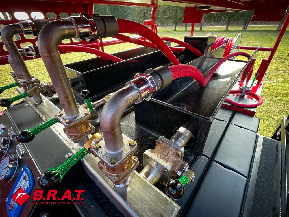 Exterior view of small fire truck showing cab, body compartments, and wheel/tire area.