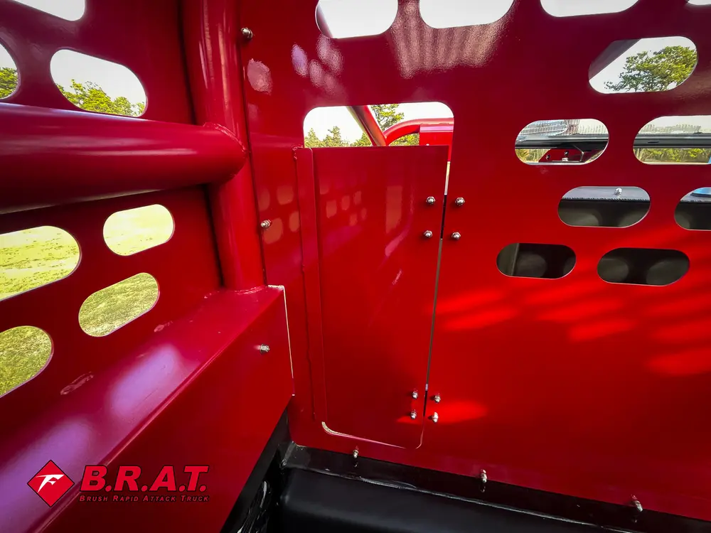 Exterior view of small fire truck showing cab, body compartments, and wheel/tire area.