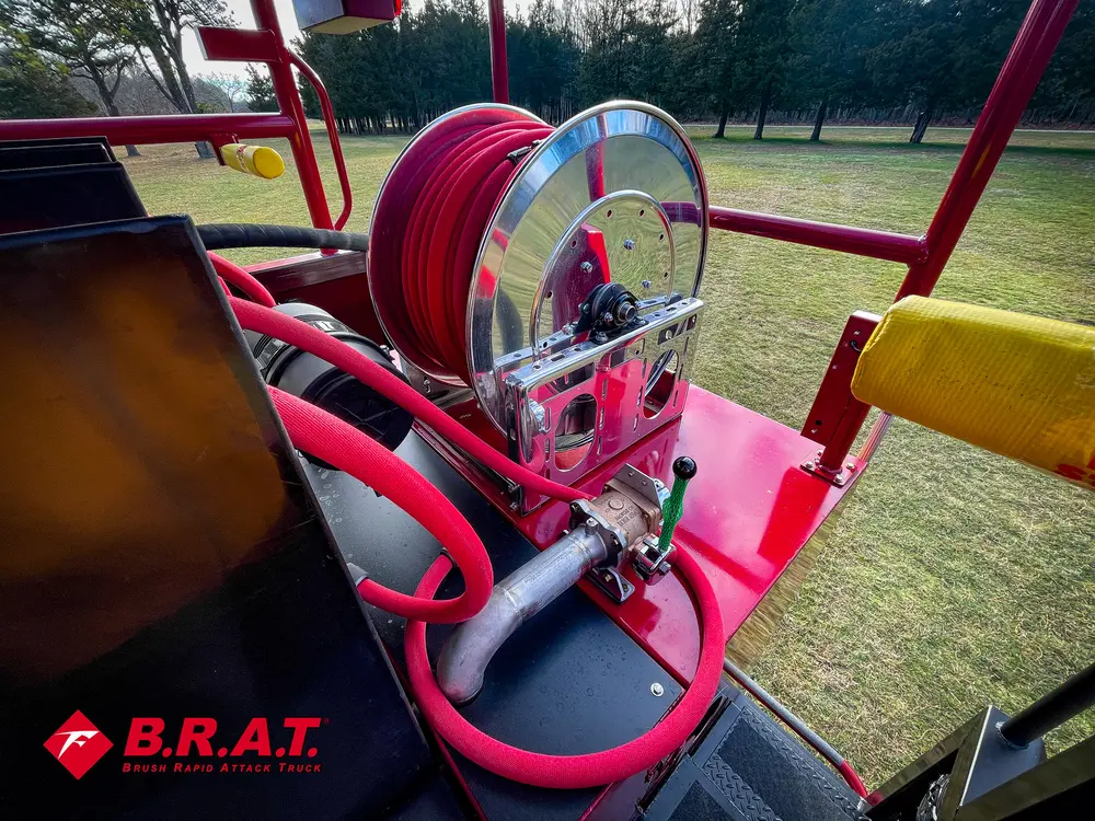 Exterior view of small fire truck showing cab, body compartments, and wheel/tire area.