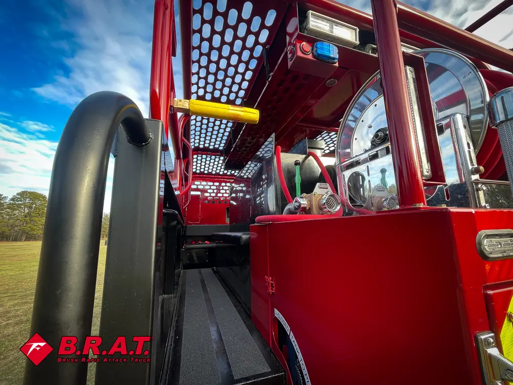 Exterior view of small fire truck showing cab, body compartments, and wheel/tire area.