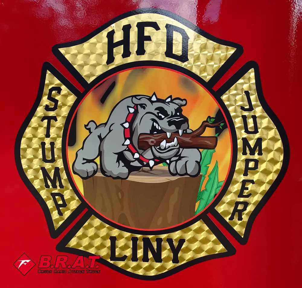 Exterior view of small fire truck showing cab, body compartments, and wheel/tire area.