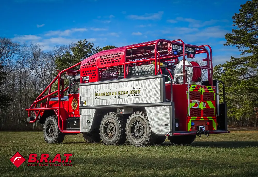 Exterior view of small fire truck showing cab, body compartments, and wheel/tire area.