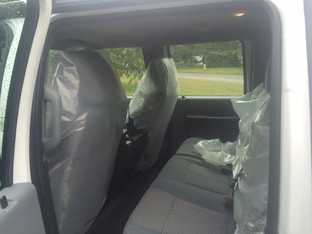 Exterior view of small fire truck showing cab, body compartments, and wheel/tire area.