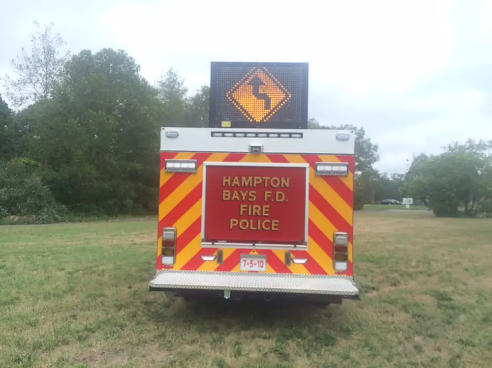 Exterior view of small fire truck showing cab, body compartments, and wheel/tire area.