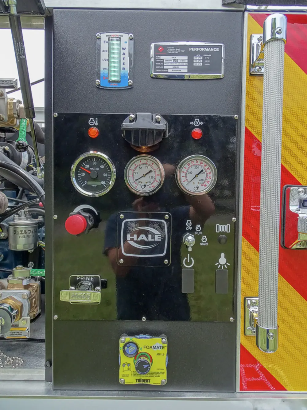 Exterior view of small fire truck showing cab, body compartments, and wheel/tire area.