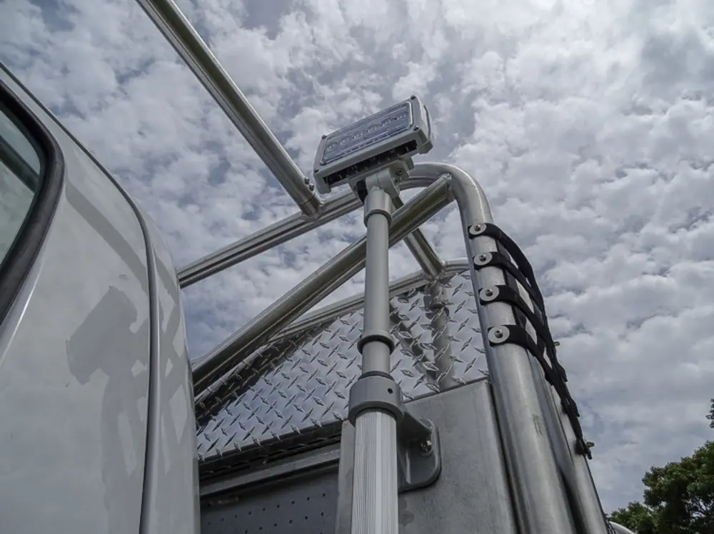 Exterior view of small fire truck showing cab, body compartments, and wheel/tire area.