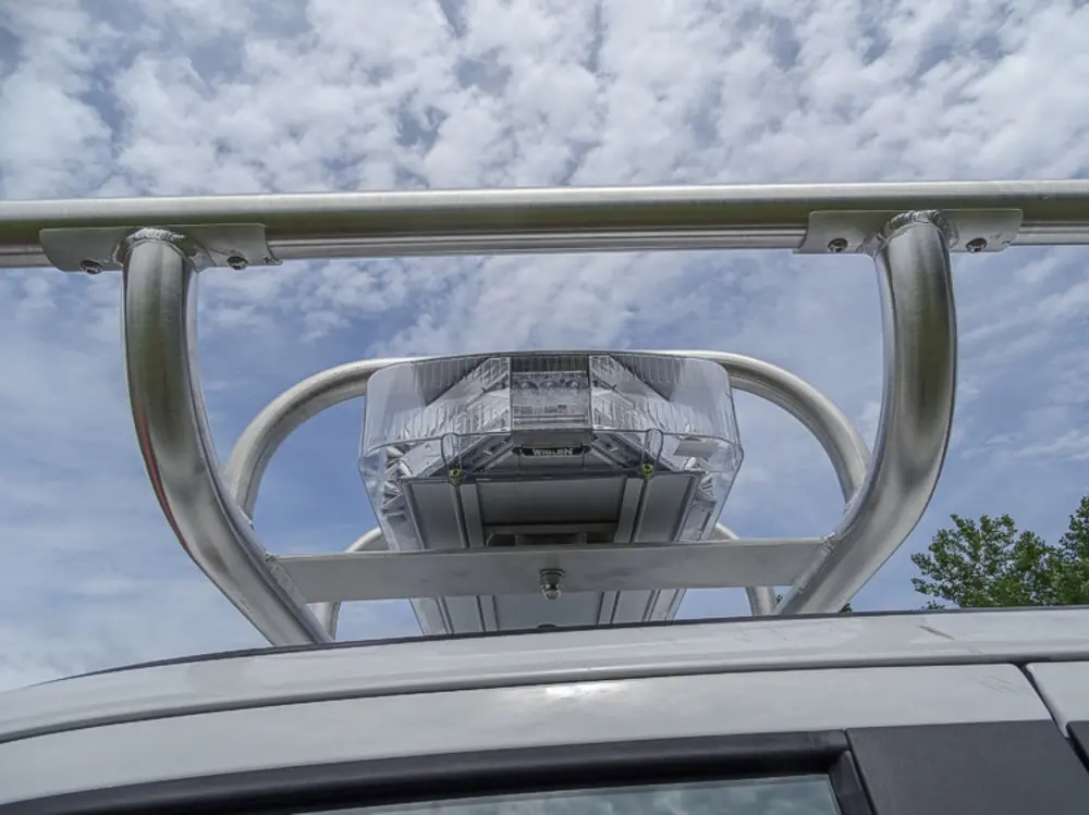 Exterior view of small fire truck showing cab, body compartments, and wheel/tire area.