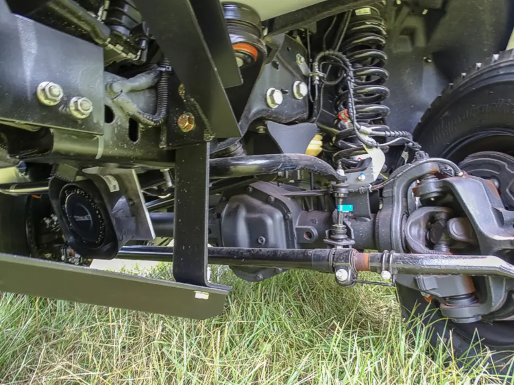 Exterior view of small fire truck showing cab, body compartments, and wheel/tire area.
