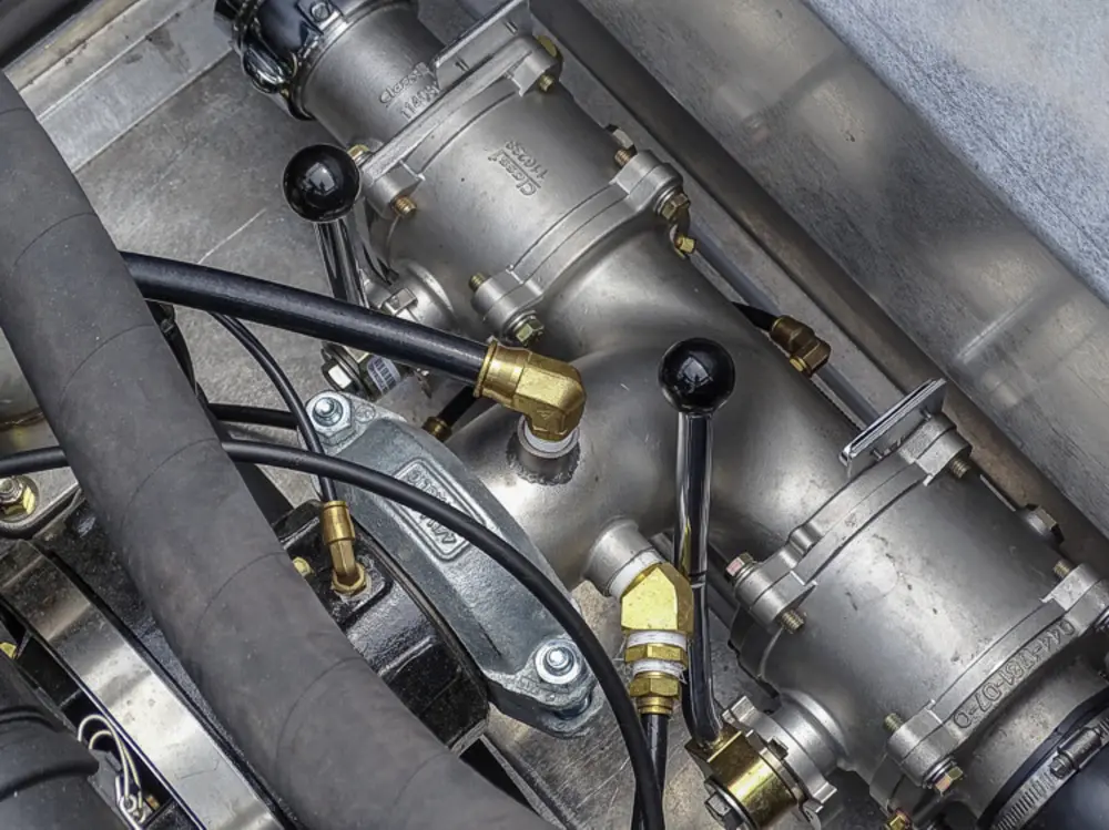 Exterior view of small fire truck showing cab, body compartments, and wheel/tire area.