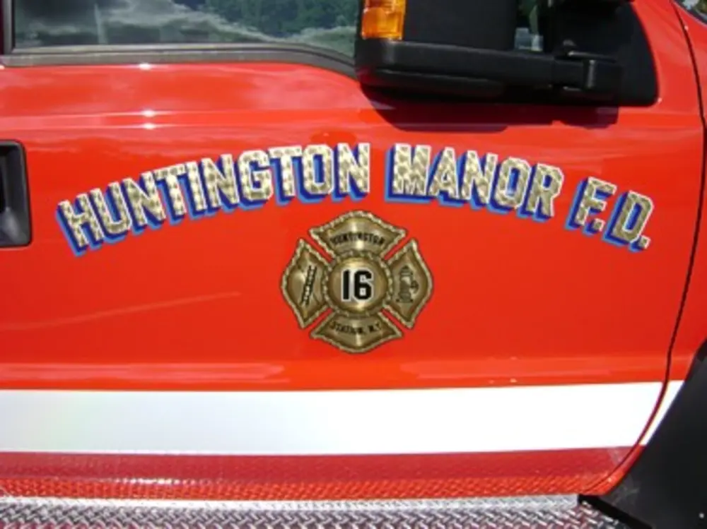 Exterior view of small fire truck showing cab, body compartments, and wheel/tire area.