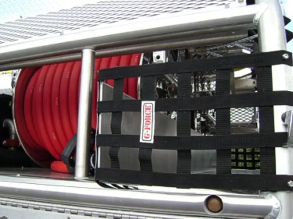 Exterior view of small fire truck showing cab, body compartments, and wheel/tire area.