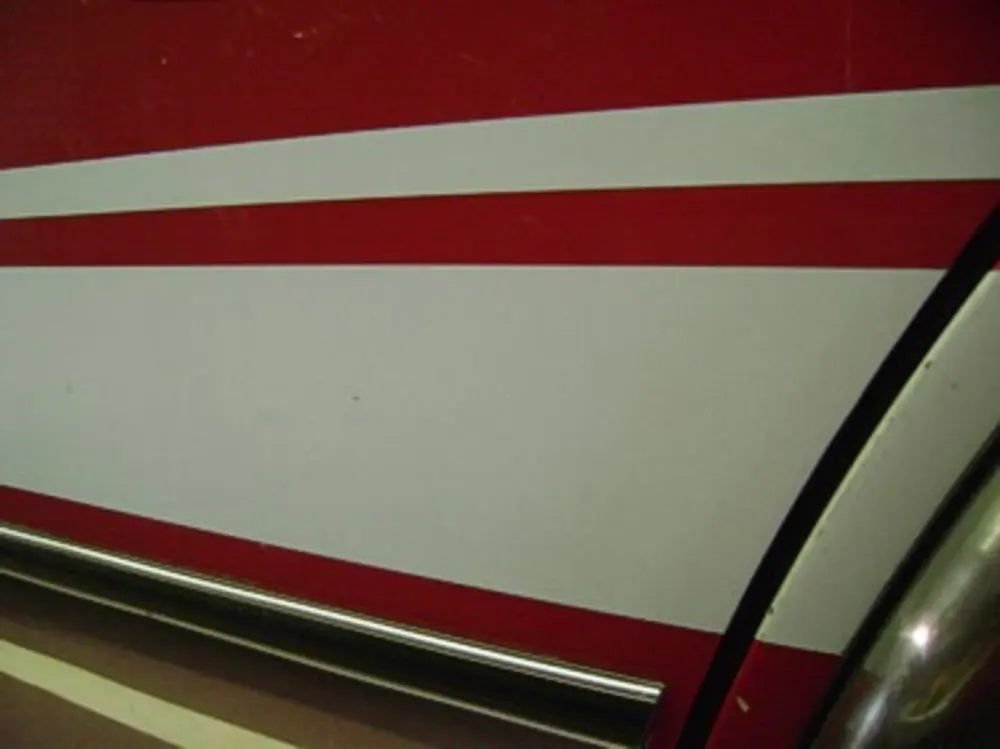 Exterior view of small fire truck showing cab, body compartments, and wheel/tire area.