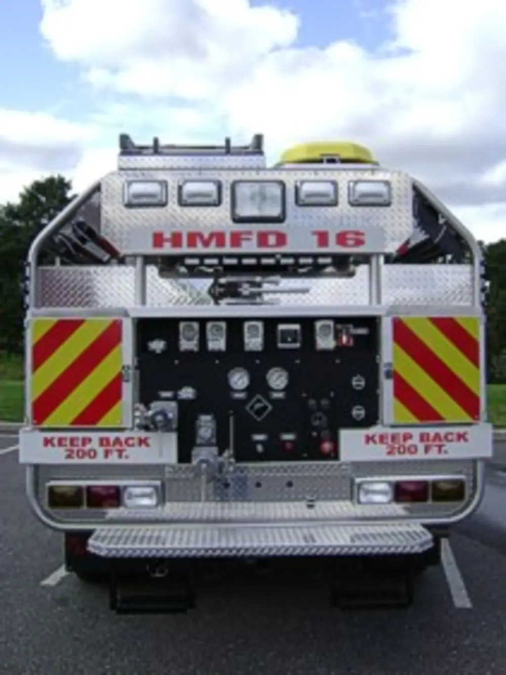 Exterior view of small fire truck showing cab, body compartments, and wheel/tire area.