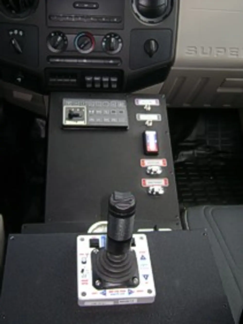 Exterior view of small fire truck showing cab, body compartments, and wheel/tire area.