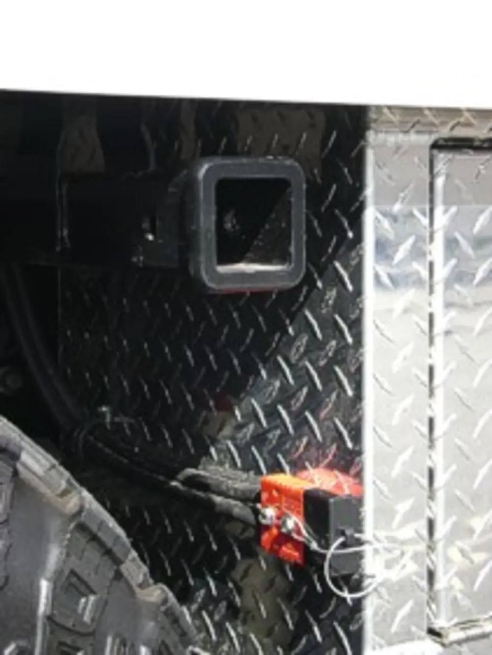Exterior view of small fire truck showing cab, body compartments, and wheel/tire area.