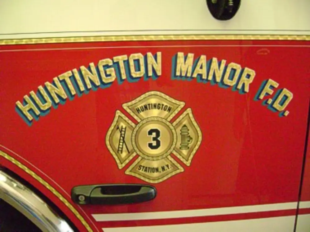 Exterior view of small fire truck showing cab, body compartments, and wheel/tire area.