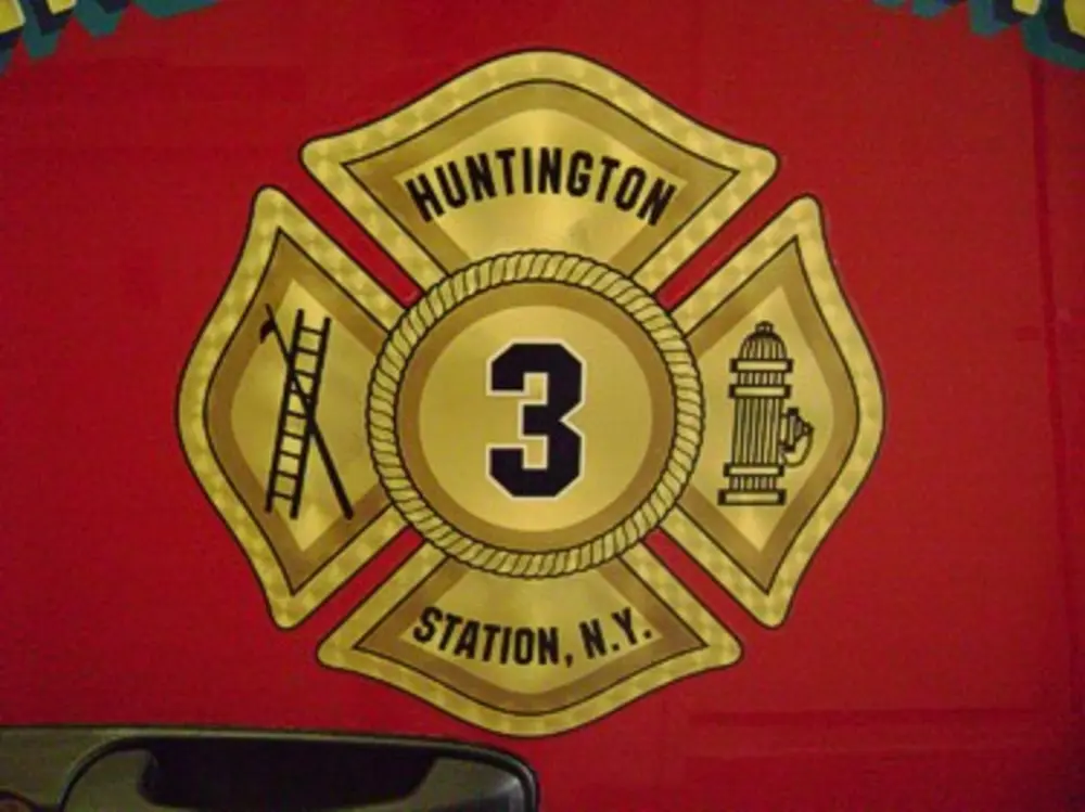 Exterior view of small fire truck showing cab, body compartments, and wheel/tire area.