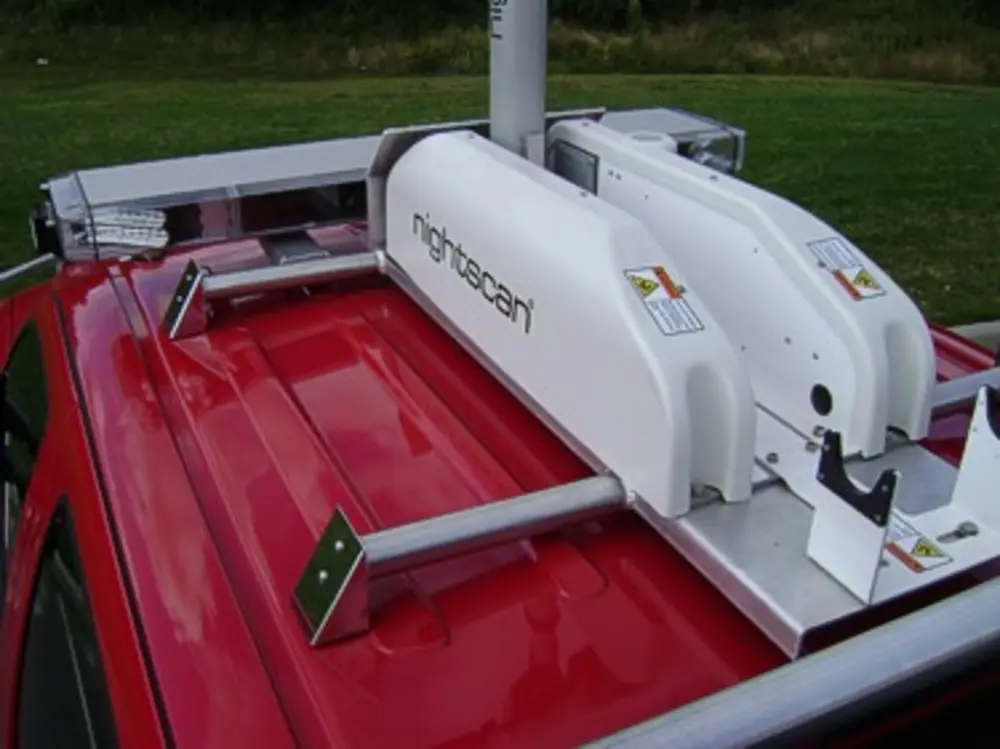 Exterior view of small fire truck showing cab, body compartments, and wheel/tire area.