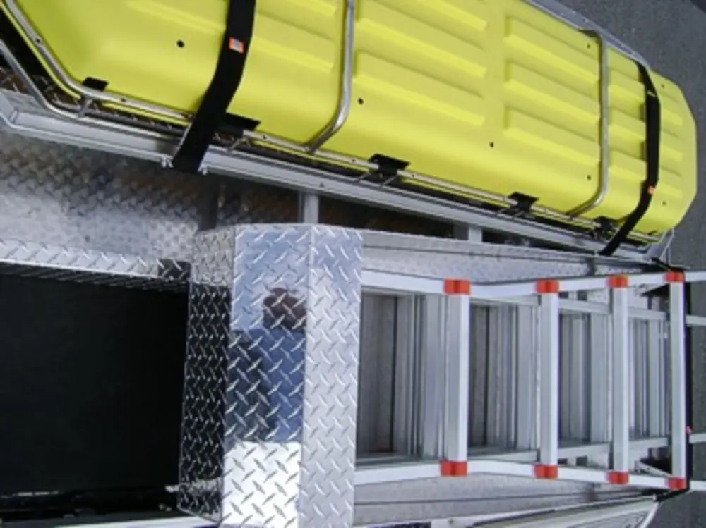 Exterior view of small fire truck showing cab, body compartments, and wheel/tire area.