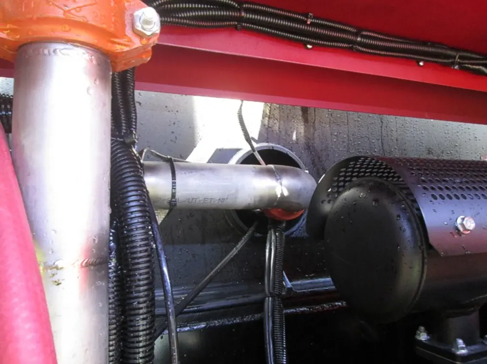 Exterior view of small fire truck showing cab, body compartments, and wheel/tire area.