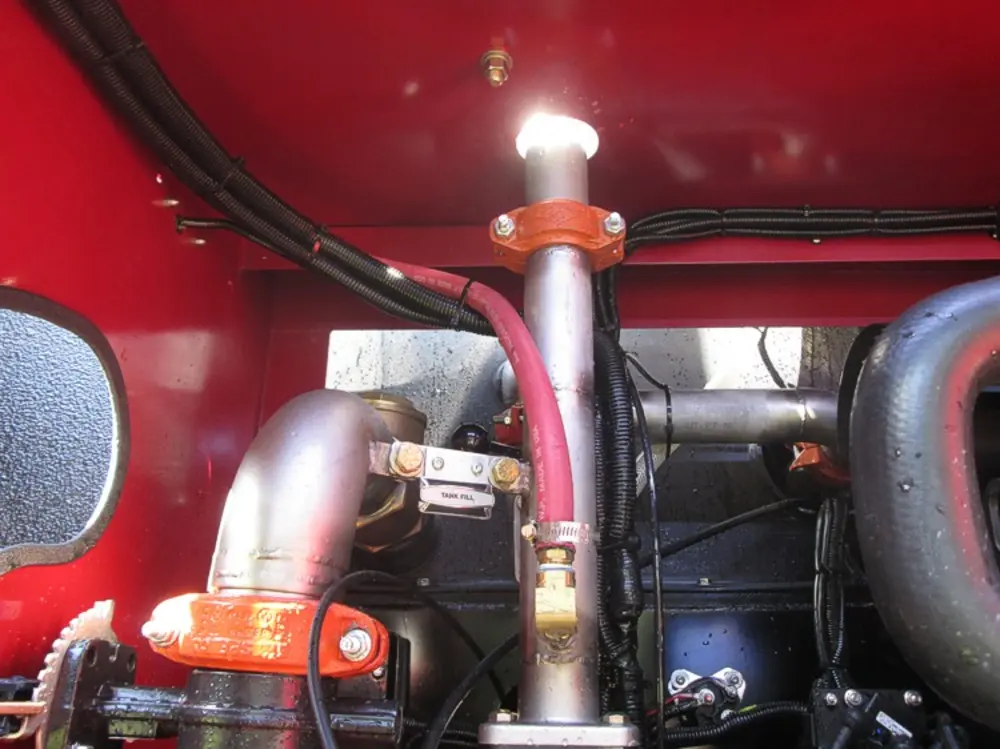 Exterior view of small fire truck showing cab, body compartments, and wheel/tire area.