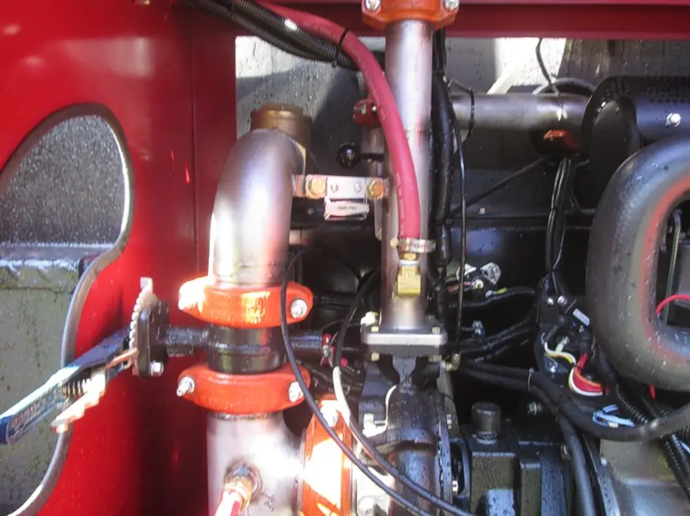 Exterior view of small fire truck showing cab, body compartments, and wheel/tire area.