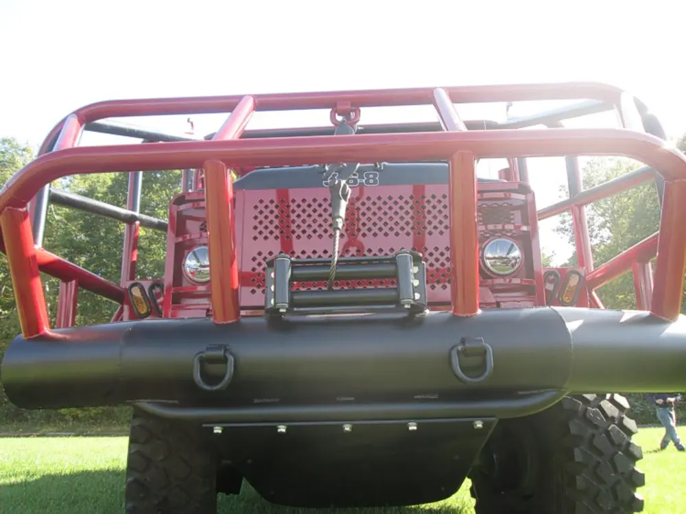 Exterior view of small fire truck showing cab, body compartments, and wheel/tire area.