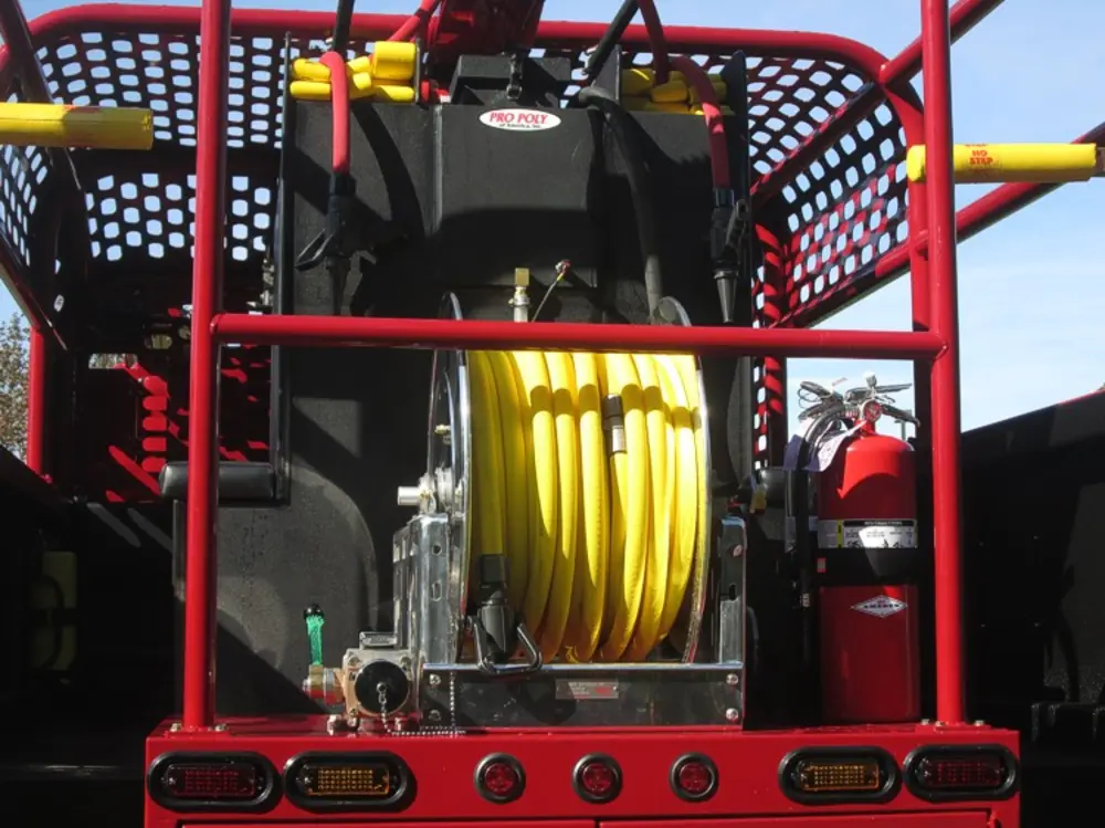 Exterior view of small fire truck showing cab, body compartments, and wheel/tire area.