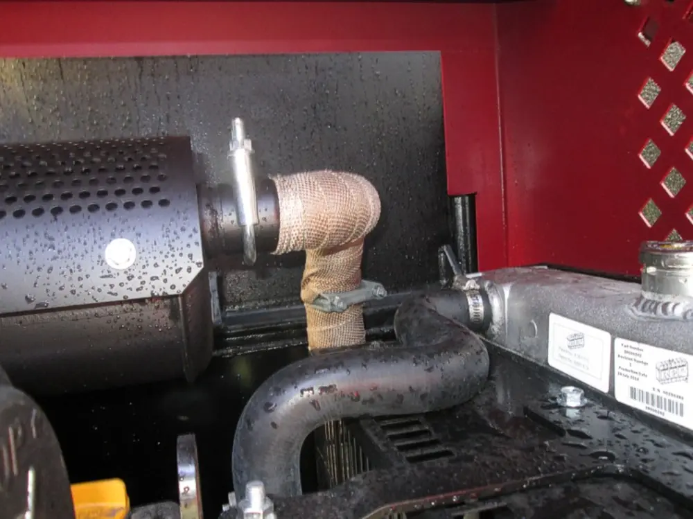 Exterior view of small fire truck showing cab, body compartments, and wheel/tire area.