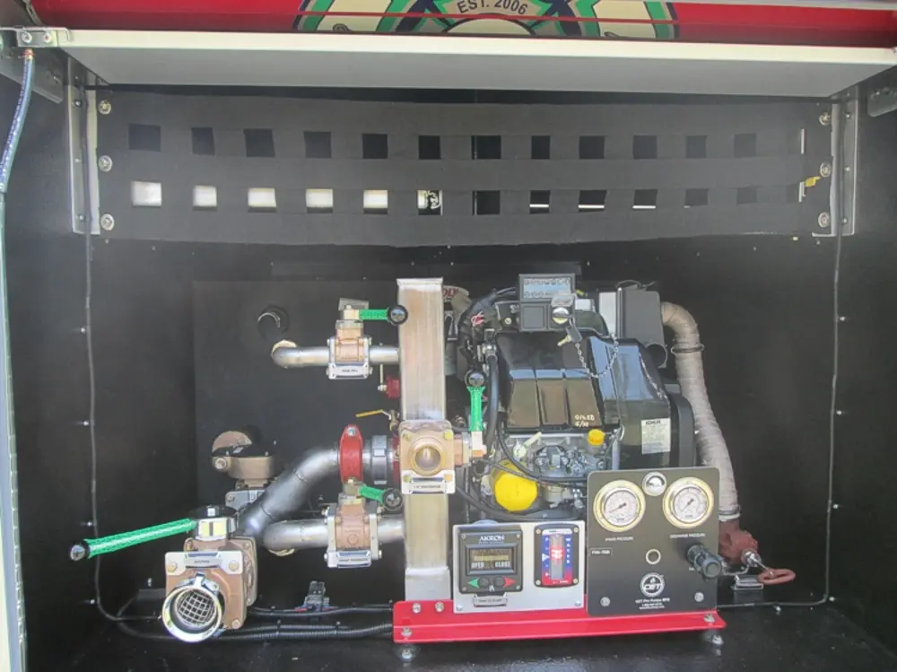 Exterior view of small fire truck showing cab, body compartments, and wheel/tire area.