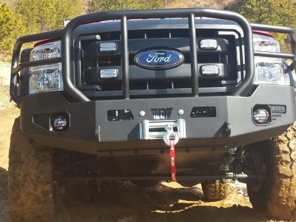 Exterior view of small fire truck showing cab, body compartments, and wheel/tire area.