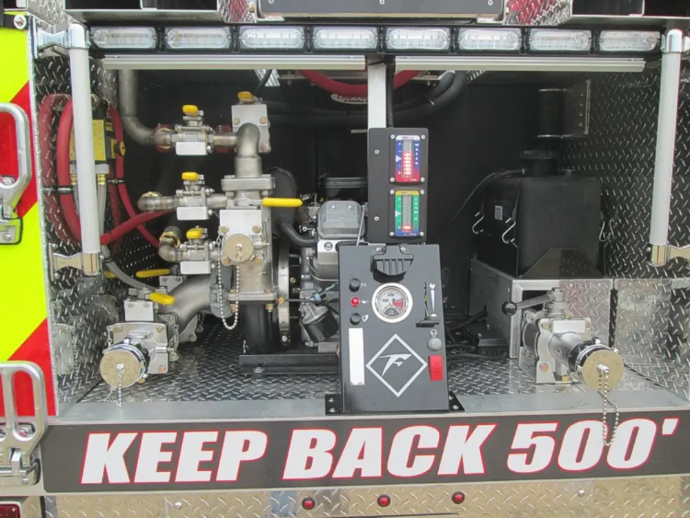 Exterior view of small fire truck showing cab, body compartments, and wheel/tire area.