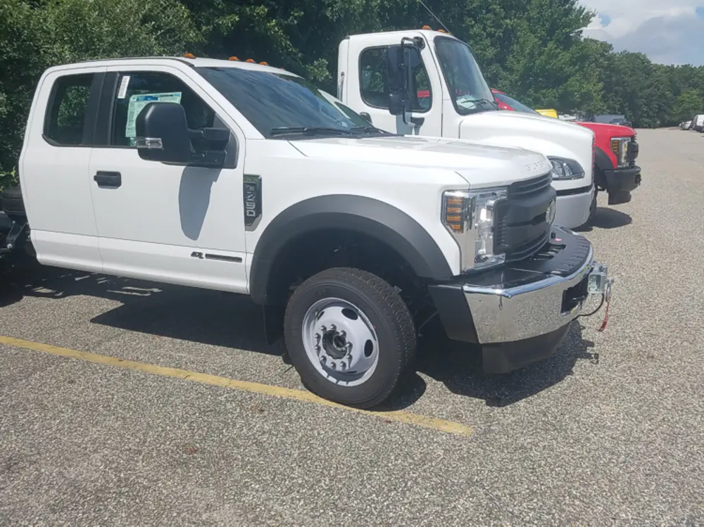 Exterior view of small fire truck showing cab, body compartments, and wheel/tire area.