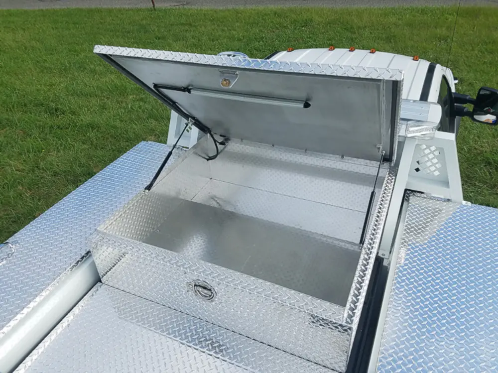 Exterior view of small fire truck showing cab, body compartments, and wheel/tire area.