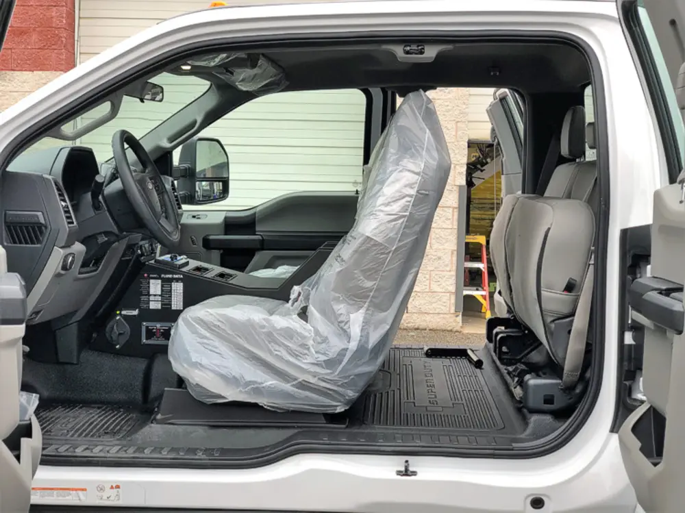Exterior view of small fire truck showing cab, body compartments, and wheel/tire area.