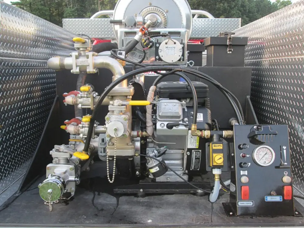 Exterior view of small fire truck showing cab, body compartments, and wheel/tire area.