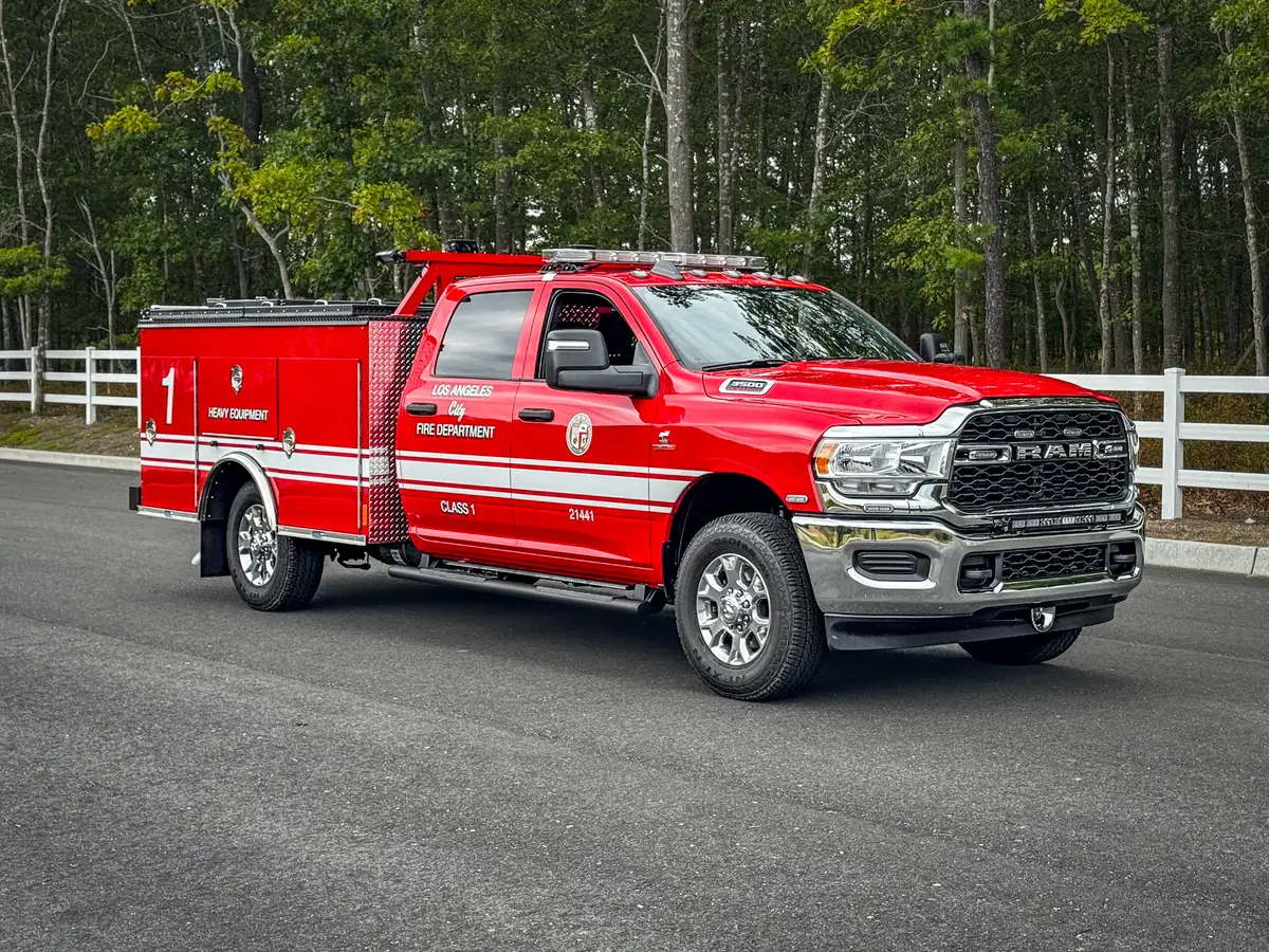 Driver-side profile of red LAFD utility truck on roadway.
