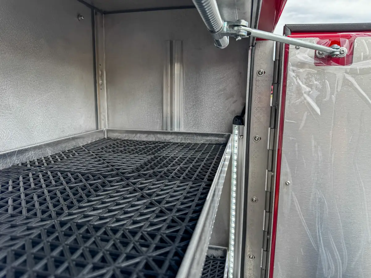 Interior of side compartment with rubberized floor mat.