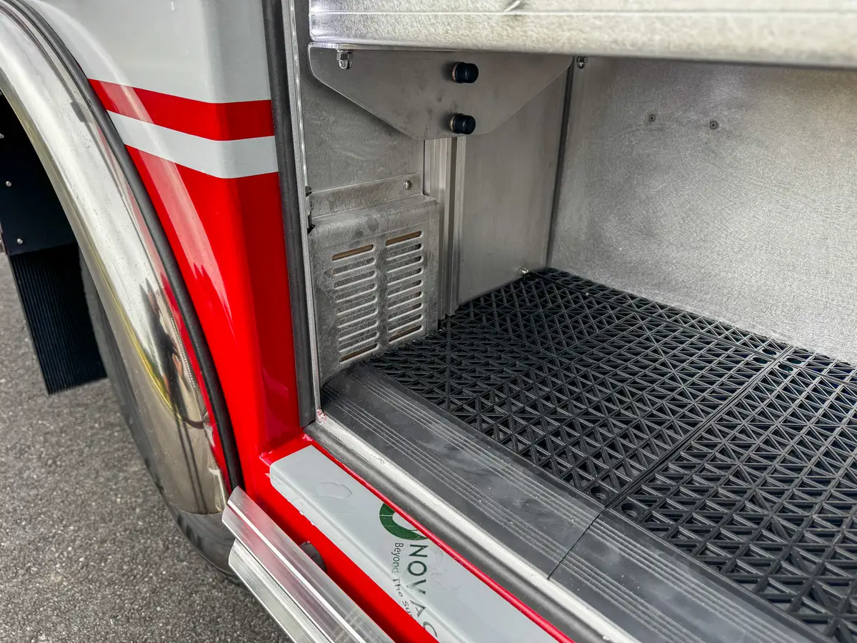 Compartment floor and lower bay close-up near door opening.
