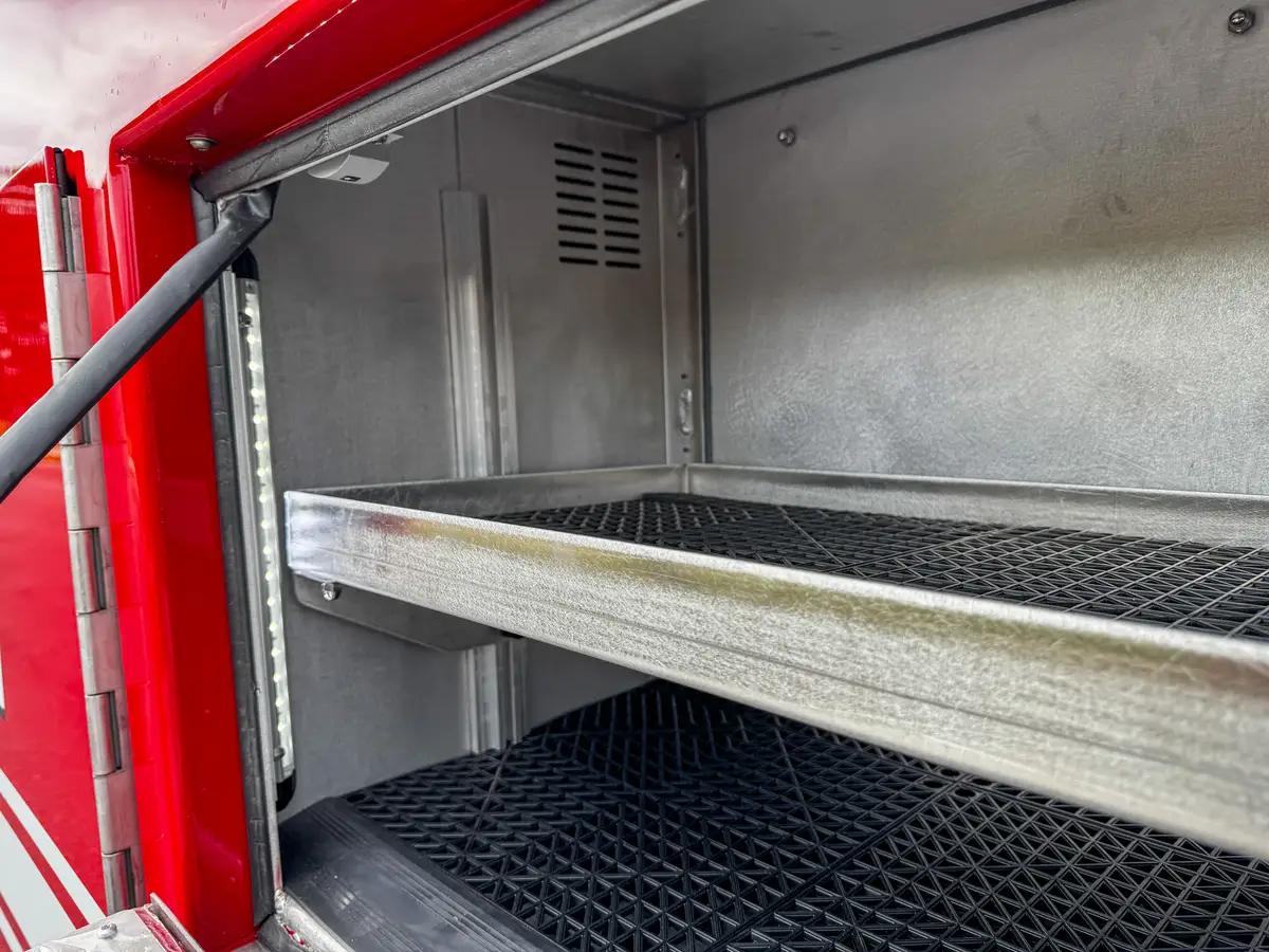 Side compartment interior with extended metal shelf.