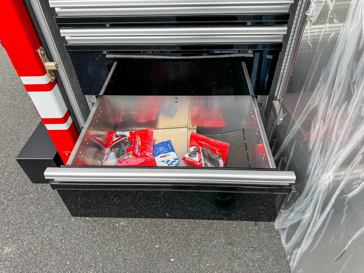 Pull-out compartment tray with red firefighting tools.