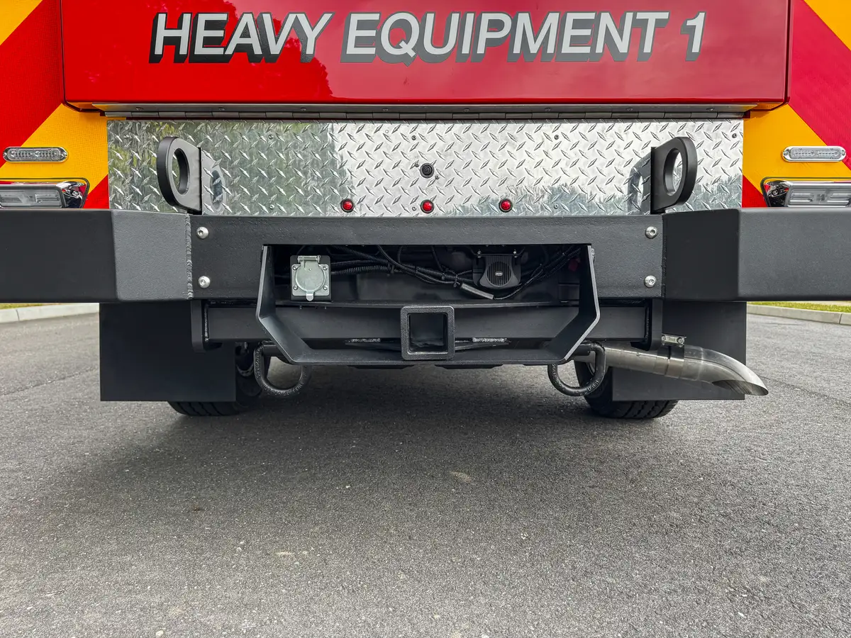 Rear step and hitch assembly under heavy equipment panel.