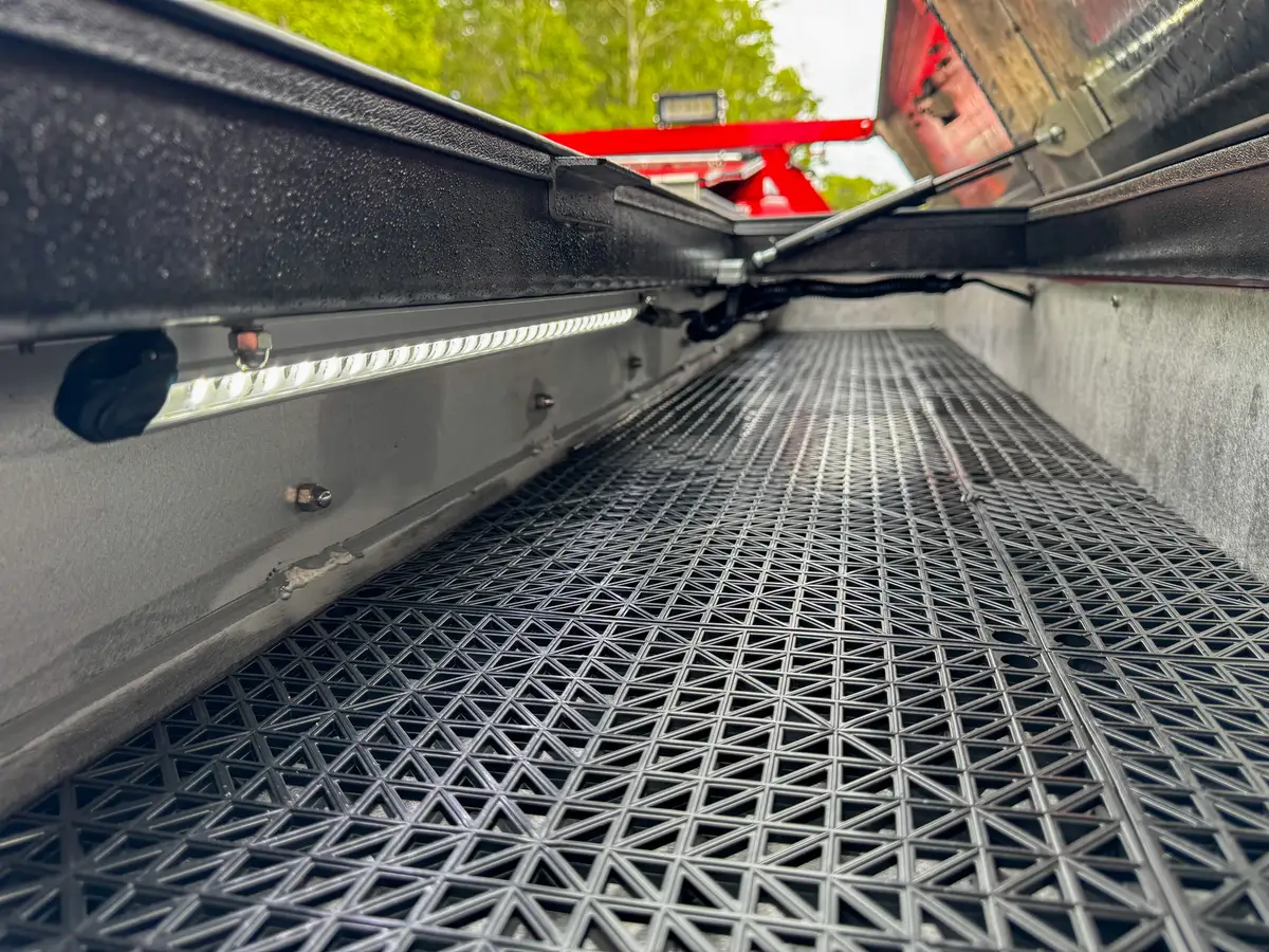 Grated bed floor and side rail channel close-up.